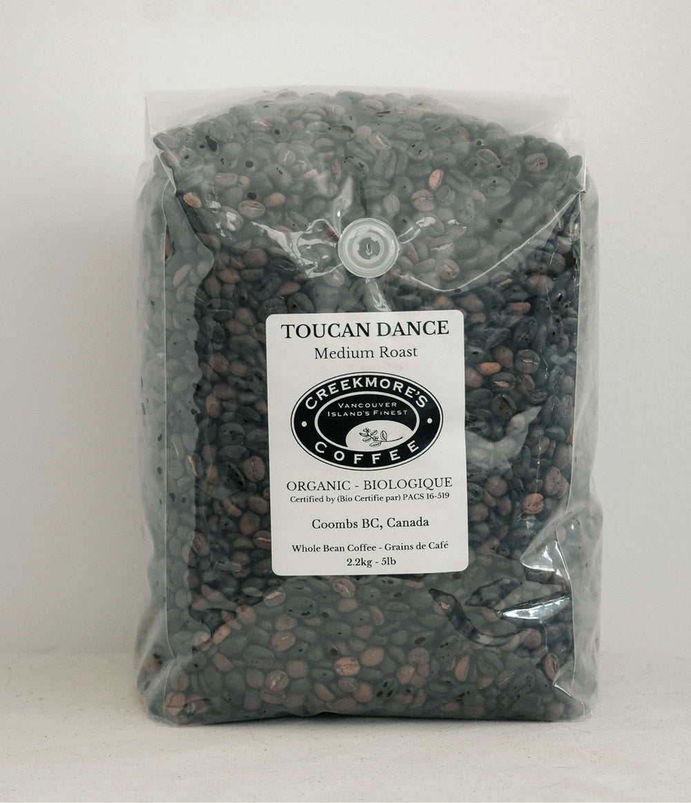 A 2.3 kg bag of Toucan Dance Medium Roast whole bean coffee from Creekmore Coffee, packaged in a clear plastic bag with a white label.
